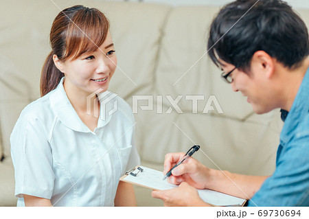 問診する看護師と男性患者 69730694