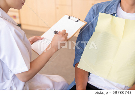 男性患者と歯科衛生士 69730743