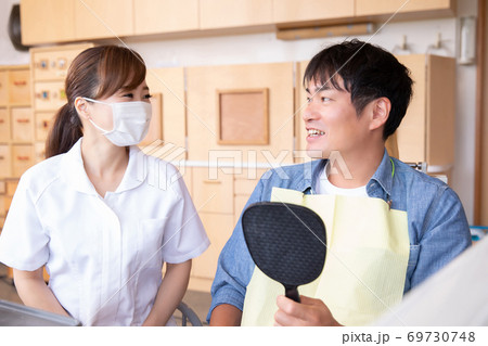 歯科衛生士と男性患者 69730748