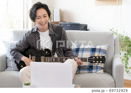 オンラインでバンド演奏をする男性【自宅】 オンラインでバンド演奏をする男性【自宅】 69732929