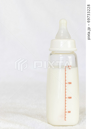 白いタオルの上にある、ミルクの入った哺乳瓶 白いタオルの上にある、ミルクの入った哺乳瓶 69733228