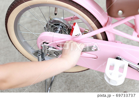 自転車の補助輪とスタンドを取り外しする女性 69733737