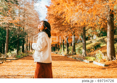 紅葉したラクウショウ並木と女性　 69734726