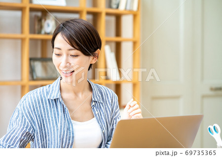 リビングでテレワーク中の女性 リビングでテレワーク中の女性 69735365