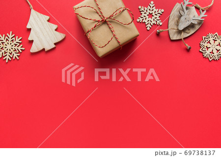 Christmas gift and wooden DIY decor on red paper.  69738137