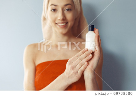 Beautiful girl standing in a studio with cream 69738380