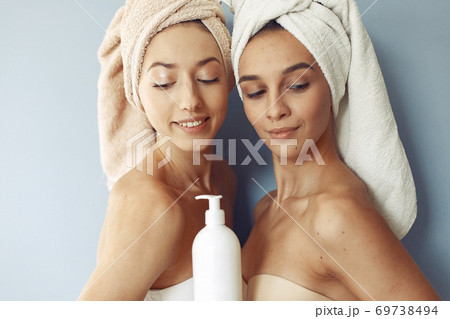 Beautiful girls standing in a studio with cream Beautiful girls standing in a studio with cream 69738494