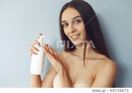 Beautiful girl standing in a studio with cream Beautiful girl standing in a studio with cream 69738673