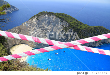 Red and white barrier tape across exotic beautiful beach background. Red and white barrier tape across exotic beautiful beach background. 69738765
