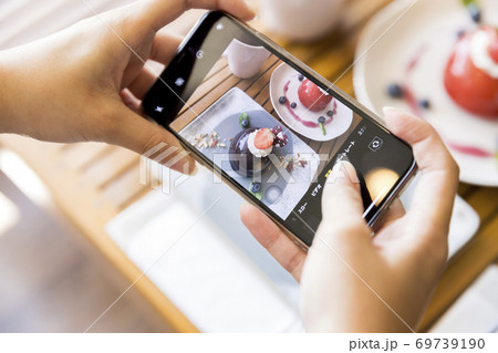 ケーキの写真をスマホで撮影をする若い女性手元 ケーキの写真をスマホで撮影をする若い女性手元 69739190
