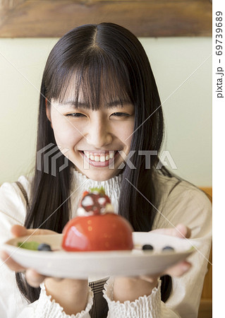 カフェで可愛いケーキを眺める若い女性　女子大生 69739689
