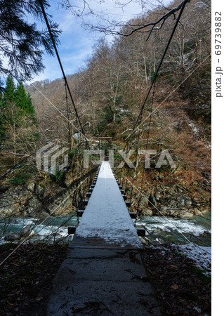雪がうっすら積もった吊橋 69739882