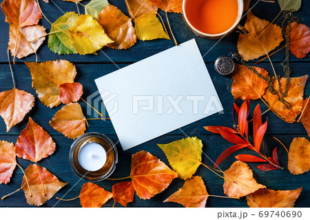 A blank greeting card or invitation with a cup of a tea, autumn leaves and a candle, an autumn stationery mockup, overhead flat lay shot A blank greeting card or invitation with a cup of a tea, autumn leaves and a candle, an autumn stationery mockup, overhead flat lay shot 69740690