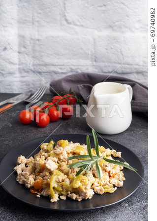 Stewed chicken minced meat with vegetables zucchini pepper spices on a black plate. copy space. 69740982