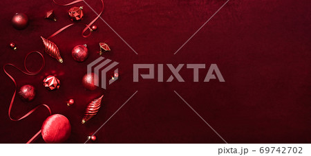 red christmas decoration bauble and ribbon on velvet red felt fabric  top view table background 69742702