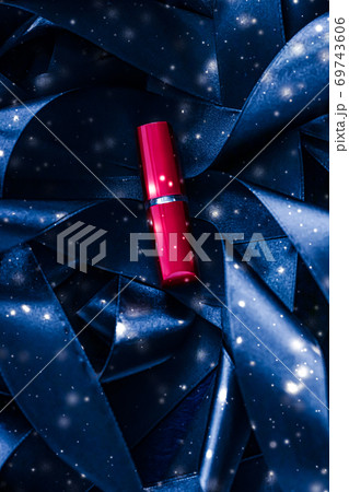 Red lipstick on blue silk and shiny glitter background, luxury make-up and beauty cosmetic Red lipstick on blue silk and shiny glitter background, luxury make-up and beauty cosmetic 69743606