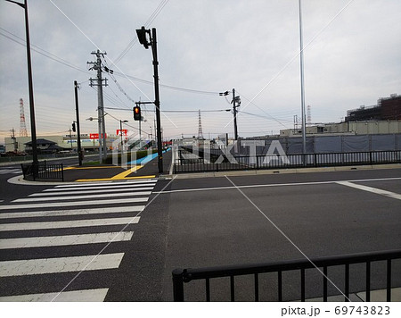 横断歩道の向こうに新しくできた歩道と自転車道、右側に商業施設の建設現場 69743823