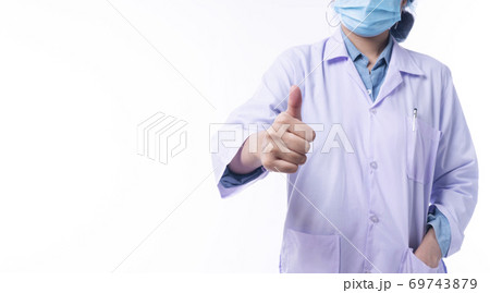 Hand of young woman doctor wear uniform coat and mask while showing thumb up 69743879