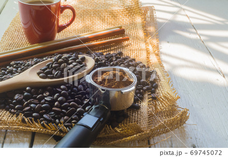 Red coffee cup and coffee bean on white wooden desk in morning 69745072