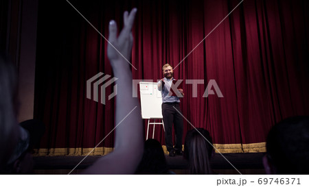 Male caucasian speaker giving presentation in hall at university or business centre workshop 69746371