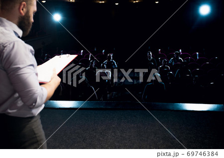 Male caucasian speaker giving presentation in hall at university or business centre workshop 69746384