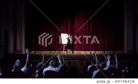 Female caucasian speaker giving presentation in hall at university or business centre workshop 69746428
