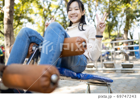 Beautiful asian child girl practicing fitness,doing sit up exercise for health and strength at city park, happy smiling female teenage doing abdominal sit ups in outdoor gym,health care concept 69747243