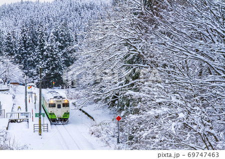 雪景色の滝谷駅と只見線の列車　福島県柳津町 69747463
