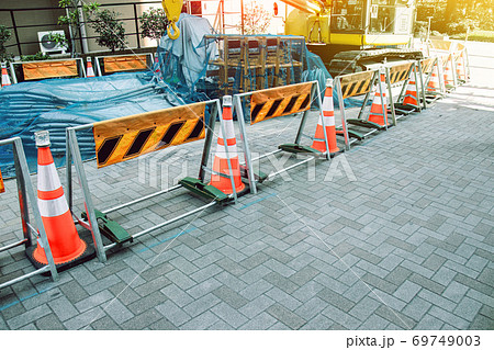 red and white traffic cones blocking construction equipment on the construction site in city 69749003