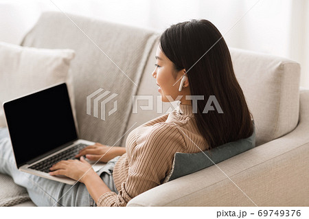 Asian girl studying online, listening music in airpods Asian girl studying online, listening music in airpods 69749376