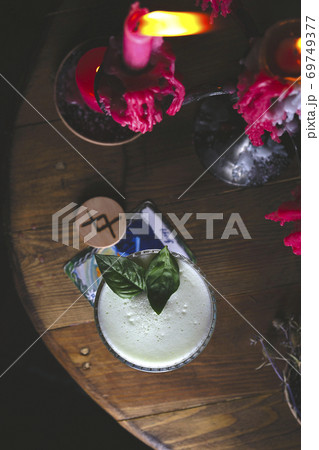 Fresh basil sour cocktail among red lights in dark style Fresh basil sour cocktail among red lights in dark style 69749377