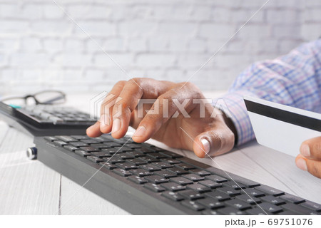 man hands holding credit card and using keyboard shopping online  69751076