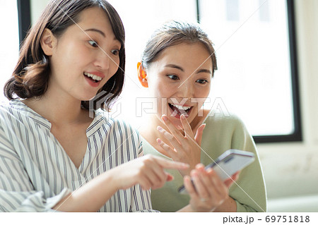 スマホを仲良く見る女性二人 スマホを仲良く見る女性二人 69751818