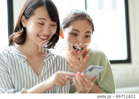 スマホを仲良く見る女性二人 スマホを仲良く見る女性二人 69751822