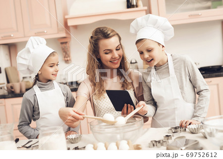 Children in aprons and hats cook chefs with mother Children in aprons and hats cook chefs with mother 69752612
