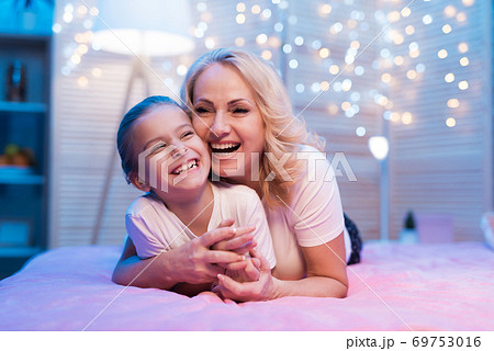 Grandmother hugs granddaughter and they smile. Grandmother hugs granddaughter and they smile. 69753016