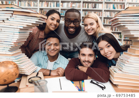 Cheerful students sitting together in the library. Cheerful students sitting together in the library. 69753485