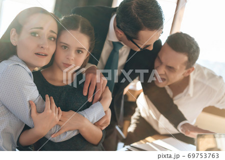 Mom hugs daughter and they are afraid dad.  69753763