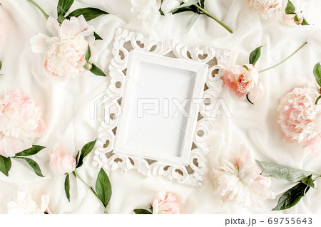 Carved, white frame decorated of beautiful and beige peonies. Flat lay, top view. Valentine's background. Floral frame. Peony texture. Carved, white frame decorated of beautiful and beige peonies. Flat lay, top view. Valentine's background. Floral frame. Peony texture. 69755643
