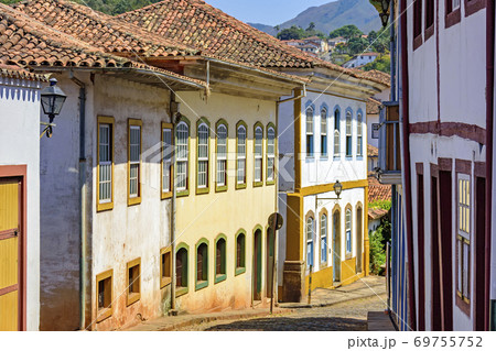 Quiet street with old colorful houses in colonial architecture, cobblestones and lanterns Quiet street with old colorful houses in colonial architecture, cobblestones and lanterns 69755752