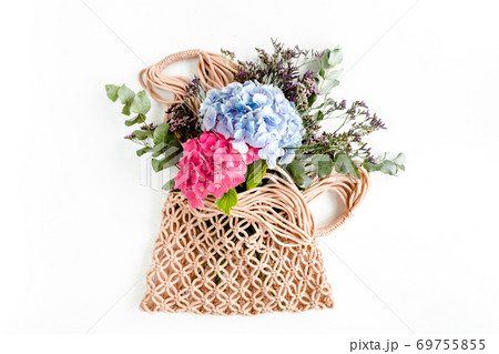 Beautiful bouquet of hydrangeas in a string, eco bag on white background. Flat lay, top view Beautiful bouquet of hydrangeas in a string, eco bag on white background. Flat lay, top view 69755855
