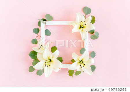 Floral frame made of white lilies and eucalyptus leaves on pink background. Flat lay, top view floral mockup with empty space for text. Floral pattern Floral frame made of white lilies and eucalyptus leaves on pink background. Flat lay, top view floral mockup with empty space for text. Floral pattern 69756241