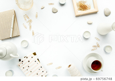 desk workspace with succulent, palm leaf branches, tea, diary, glasses and golden clips on white background. flat lay, top view desk workspace with succulent, palm leaf branches, tea, diary, glasses and golden clips on white background. flat lay, top view 69756748