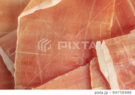 Dry Spanish ham, jamon serrano, bellot, Italian ham prosciutto crudo or parma, chopped layers, close-up, macro 69756986