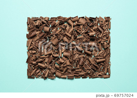 Chocolate pieces pile isolated on blue background. Chopped chocolate top view 69757024