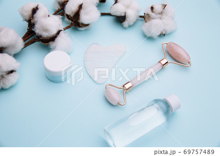 Pink roller face massager and gouache scraper. Anti age, lifting and toning treatment concept Pink roller face massager and gouache scraper. Anti age, lifting and toning treatment concept 69757489