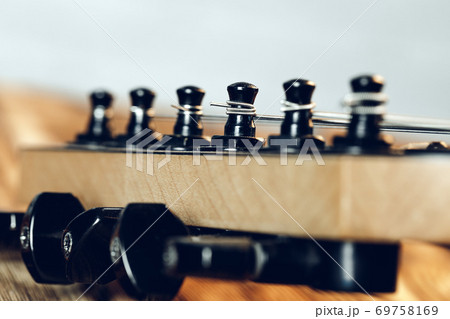 Guitar headstock with tuners on dark background Guitar headstock with tuners on dark background 69758169