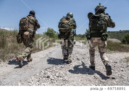 Army soldiers running on road in abandoned area Army soldiers running on road in abandoned area 69758891