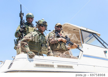 Army special forces soldiers on speed boat stern Army special forces soldiers on speed boat stern 69758908