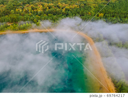 Aerial view of morning mist fog landscape, lake in blurred fog background Aerial view of morning mist fog landscape, lake in blurred fog background 69764217